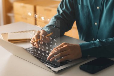 Dizüstü bilgisayar Planı kullanan işadamı, kilometre taşı planlama ve sanal çizelge çizelgelerini içeren görevleri çalışır ve günceller.