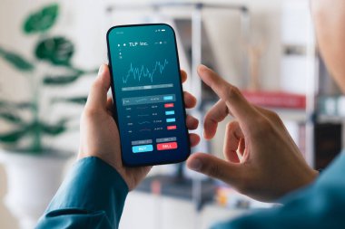 İşadamları borsa yatırımlarıyla ticaret verilerini analiz etmek için akıllı telefon kullanıyorlar. Ekranda borsa grafiği olan akıllı telefon. Finansal borsa.