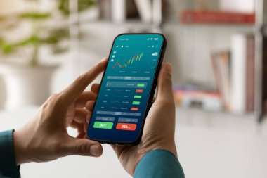 İşadamları borsa yatırımlarıyla ticaret verilerini analiz etmek için akıllı telefon kullanıyorlar. Ekranda borsa grafiği olan akıllı telefon. Finansal borsa.