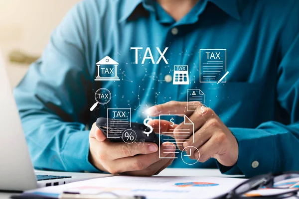 納税のためのオンライン個人所得税申告書 個人所得税計算書を記入するために彼のラップトップコンピュータとスマートフォンを使用してビジネスマン — ストック写真