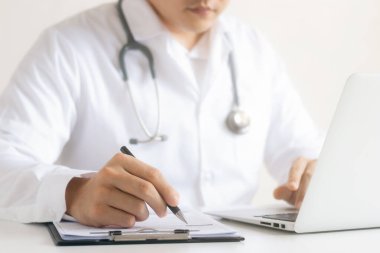 Doktor tıbbi raporu detaylı fiziksel muayene, hasta veri kaydını dizüstü bilgisayarlarla analiz eder..