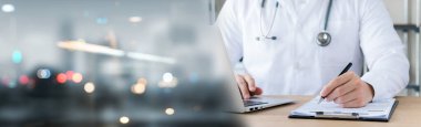 Doktor, tıbbi raporu detaylı bir fiziksel muayene laptoplu hasta veri kaydını gece bulanıklaştırılmış metin fotokopi alanı, resim boyutu yatay olarak analiz eder..