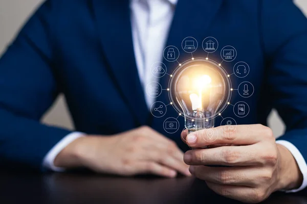 Innovation through ideas and inspiration ideas. Human hand holding light bulb to illuminate, idea of creativity and inspiration concept of sustainable business development.