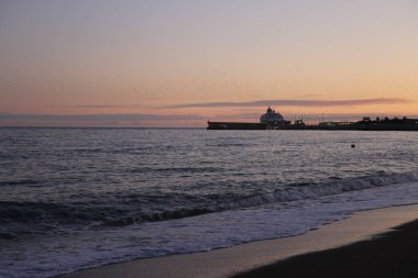 Deniz manzaralı ve deniz kenarında pembe günbatımı olan bir yaz akşamı
