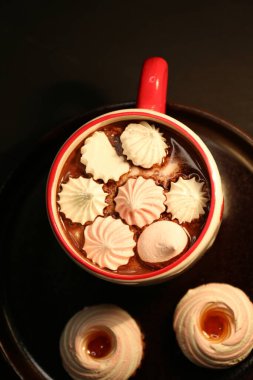 Koyu arkaplanda lokum olan bir fincan kakao.