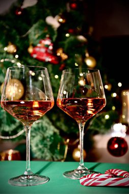 Yılbaşı ağacının arka planında şenlikli bir hayat için iki kadeh şampanya.