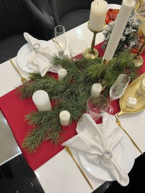 Şamdanlarla, peçetelerle ve Noel ağacıyla servis edilen şenlik masası.