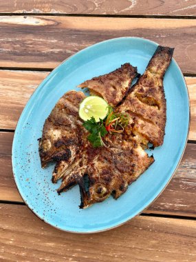 Tabakta sebzeli ızgara balık.