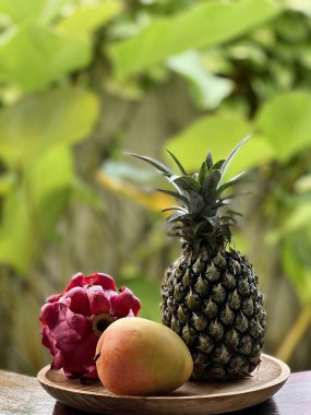 ejderha meyvesi, ananas ve mango tropikal olarak ahşap tabakta