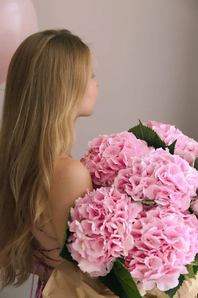 girl with long blond hear and flowers hydrangeas