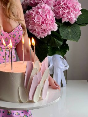 Bir doğum günü kızının ellerinde pembe renkli doğum günü pastası