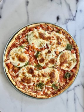 Pizza ve beyaz şarap masada.