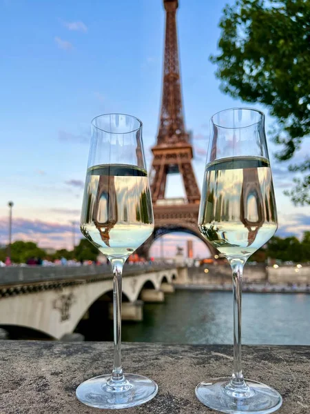 glasses of white wine in the background tower in Paris