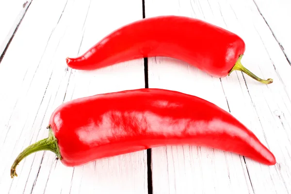 Pimentos vermelhos em uma tábua branca — Fotografia de Stock