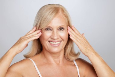 Güzel son sınıf güzeli yumuşak cildine dokunuyor. Güzellik fotoğrafçılığı