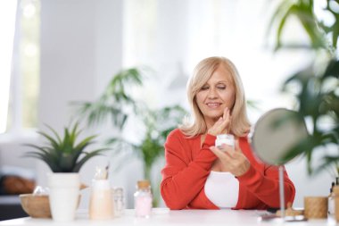 Yaşlı bir vlogger evde oturuyor ve yeni anti-yaş kreminden bahsediyor..