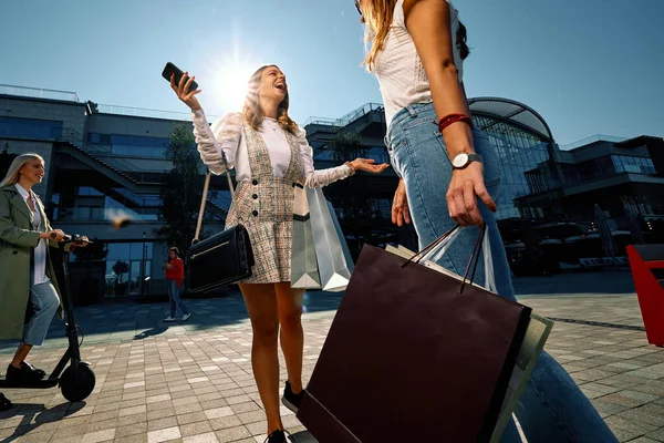 Dos Mujeres Jóvenes Atractivas Están Pie Calle Con Bolsas Compras —  Fotos de Stock