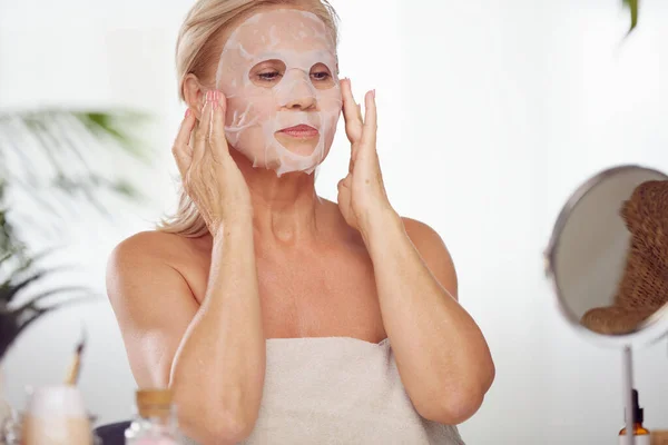 Senior Woman Putting Beauty Face Mask Her Face While Sitting — Stock Photo, Image