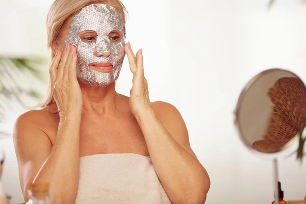 Senior Woman Putting Beauty Face Mask Her Face While Sitting — Stock Photo, Image