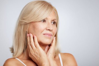 Sarışın, güzel bir kadının portresi. Poz veriyor ve başka tarafa bakıyor. Güzellik fotoğrafçılığı