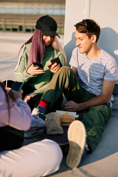 Szczęśliwi Nastoletni Przyjaciele Siedzą Zewnątrz Używają Telefonów Wieszania Portalach Społecznościowych — Zdjęcie stockowe