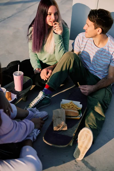 Mała Grupa Nastolatków Siedząca Zewnątrz Jedząca Fast Food Przekąskę Miejskie — Zdjęcie stockowe