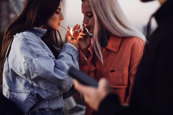 Two Rebellious Teenage Girls Standing Outdoors Lighting Cigarettes Teenagers Smoking — Stock Photo, Image