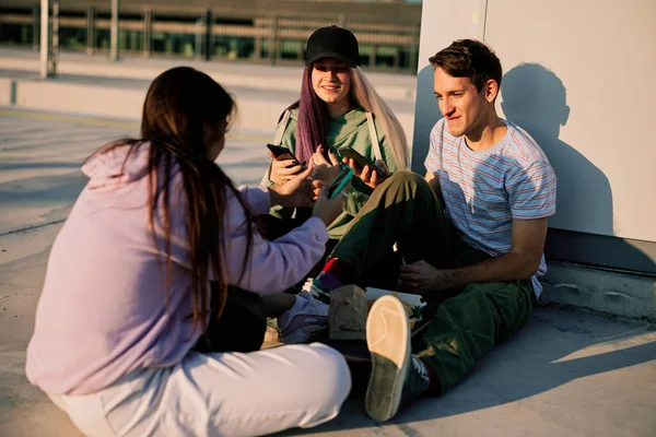 Szczęśliwi Nastoletni Przyjaciele Siedzą Zewnątrz Używają Telefonów Wieszania Portalach Społecznościowych — Zdjęcie stockowe