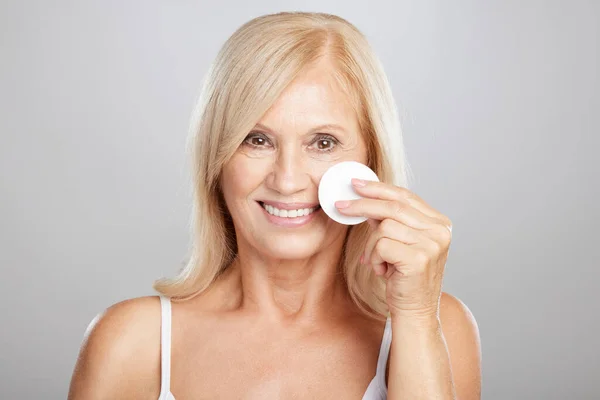 Una Donna Anziana Bionda Sta Rimuovendo Trucco Con Batuffolo Cotone — Foto Stock