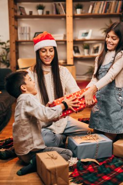 Çocuklar hediyeler için kavga ederken anneleri oturur ve tartışmaları Noel ruhuyla çözmeye çalışır..