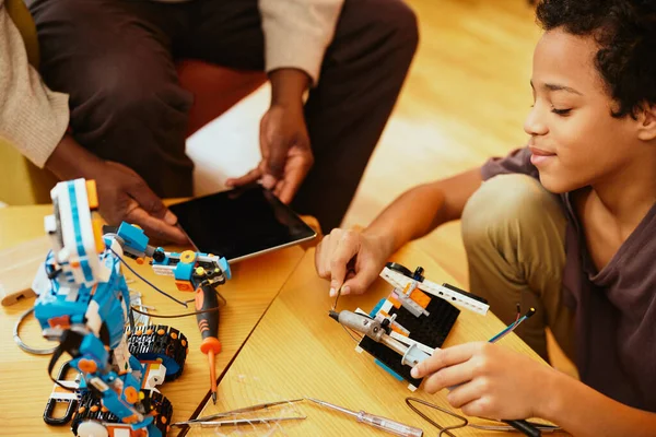 爷爷和孙子在家里一起制造机器人机器人和电子教育 — 图库照片