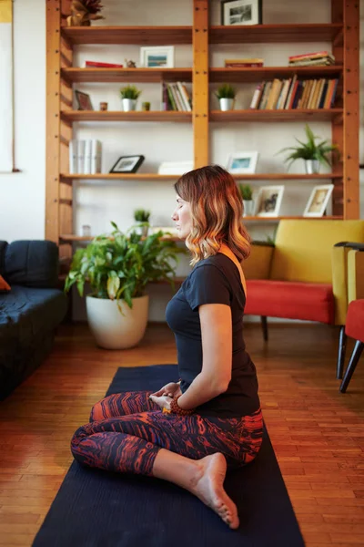 Eine Frau Mittleren Alters Yogahosen Sitzt Hause Auf Einer Yogamatte — Stockfoto