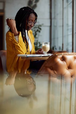 Kafede oturan ve final sınavına çalışan Afrikalı bir öğrenci. Yüksek öğrenim ve öğrenim hayatı.