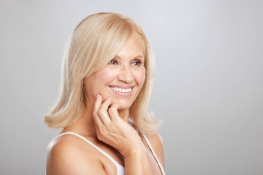 Sarışın, güzel bir kadının portresi. Poz veriyor ve başka tarafa bakıyor. Güzellik fotoğrafçılığı