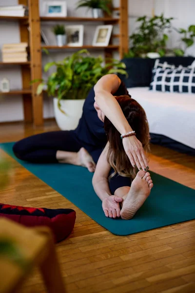 Una Mujer Flexible Está Sentada Una Esterilla Yoga Practicando Yoga — Foto de Stock