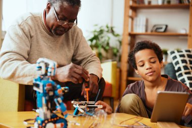 Büyükbaba ve torun evde robot yapıyor. Robot ve elektronik eğitimi.