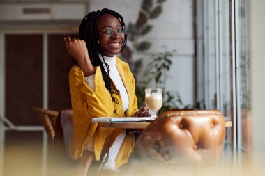 Kafede oturan ve final sınavına çalışan Afrikalı bir öğrenci. Yüksek öğrenim ve öğrenim hayatı.