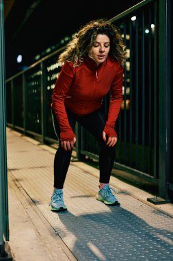 Genç ve formda bir sporcu gece tren istasyonunda uzun bir koşudan sonra dinleniyor. Şehir dışında mola veren bir gece kaçağı..