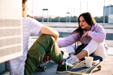 Dışarıda oturan ve abur cubur olarak fast food yiyen bir grup genç. Şehirdeki gençler okuldan sonra takılıyorlar..