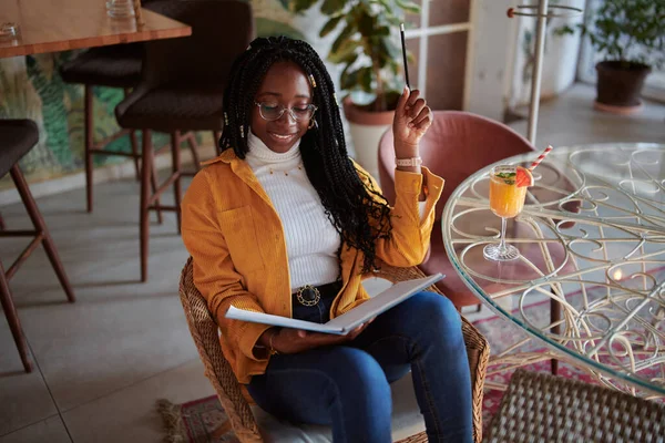 Szczęśliwa Afrykańska Studentka Siedzi Kawiarni Notatnikiem Rękach Uczy Się Egzaminu — Zdjęcie stockowe