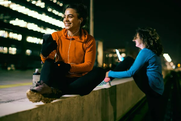 Geceleri Gülümseyen Zinde Bir Sporcu Kadın Dışarıda Oturuyor Dinleniyor Telefon — Stok fotoğraf
