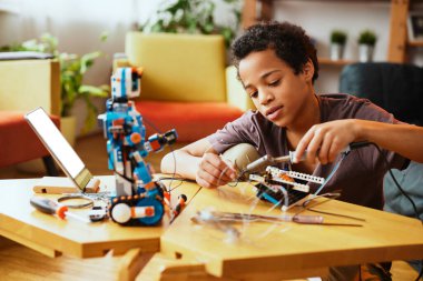 Robot yapan ve evde eğlenen bir öğrenci..