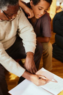 Büyükbaba, torununun matematik problemini evde kontrol ediyor..