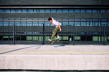 Genç bir çocuk kaykay üzerinde numaralar yapıyor..