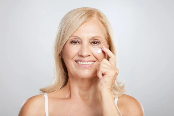 Une Séduisante Blonde Senior Qui Met Crème Âge Photographie Beauté — Photo