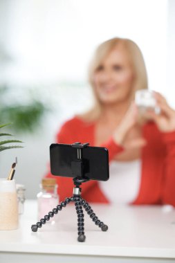 Evde oturup yeni güzellik ürünleri hakkında konuşan yaşlı bir vlogger. Önplana odaklan