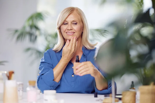 Een Oudere Vrouw Die Thuis Stichtingscrème Haar Hand Doet Probeert — Stockfoto