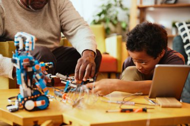 Bir dede torununa evde otururken nasıl robot yapılacağını gösteriyor..