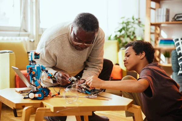 Abuelo Mostrando Nieto Cómo Hacer Robot Mientras Está Sentado Casa — Foto de Stock