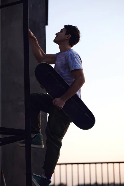 Silhouette Rebellious Teenager Climbs Ladders Building Skateboard Hands — Stock Photo, Image